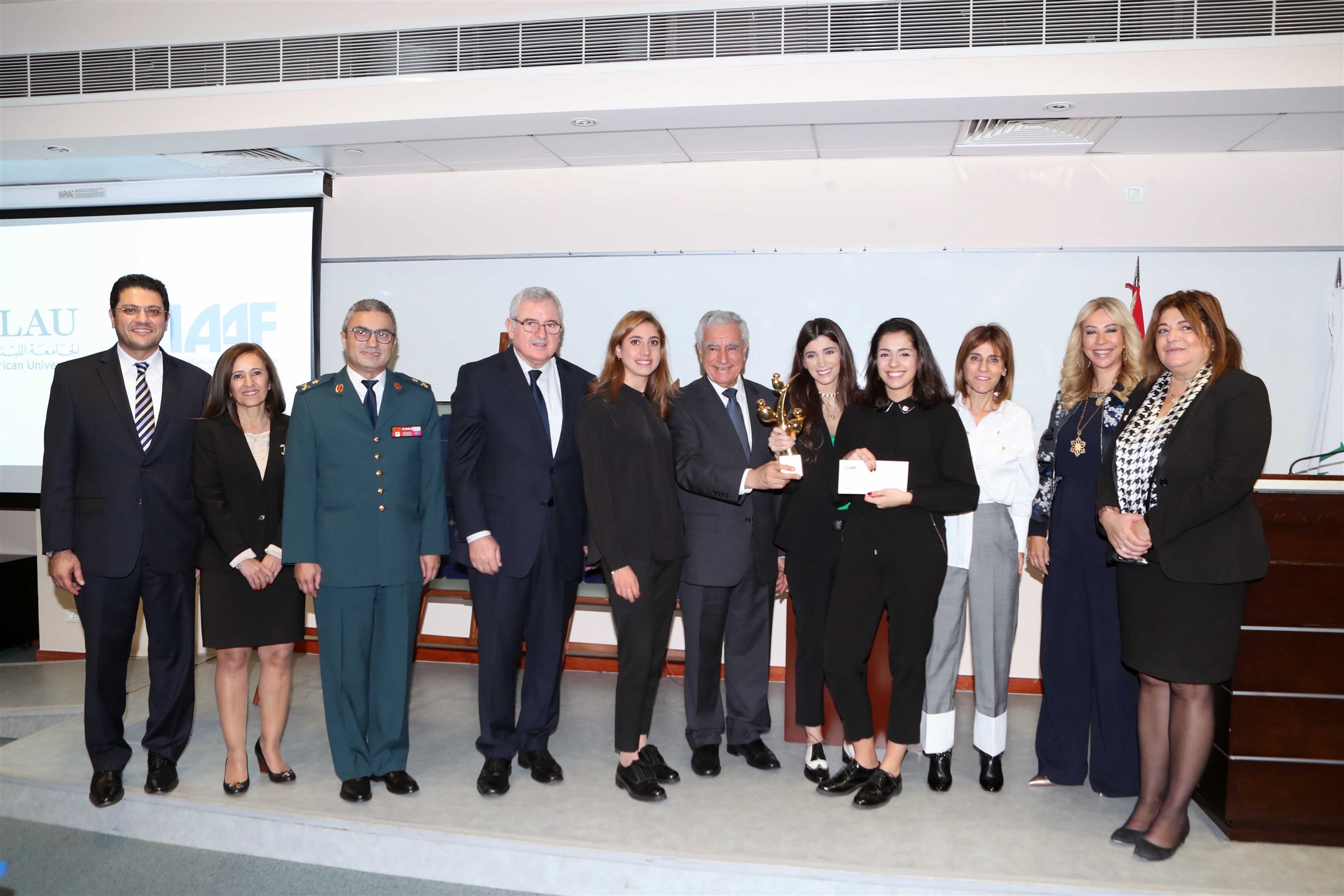 the winners of the beirut campus iaaf awards claiming their trophy for their project “lmn” that empowers people with special needs through providing them with job opportunities and teaching them handmade clothing that challenges traditional wear.