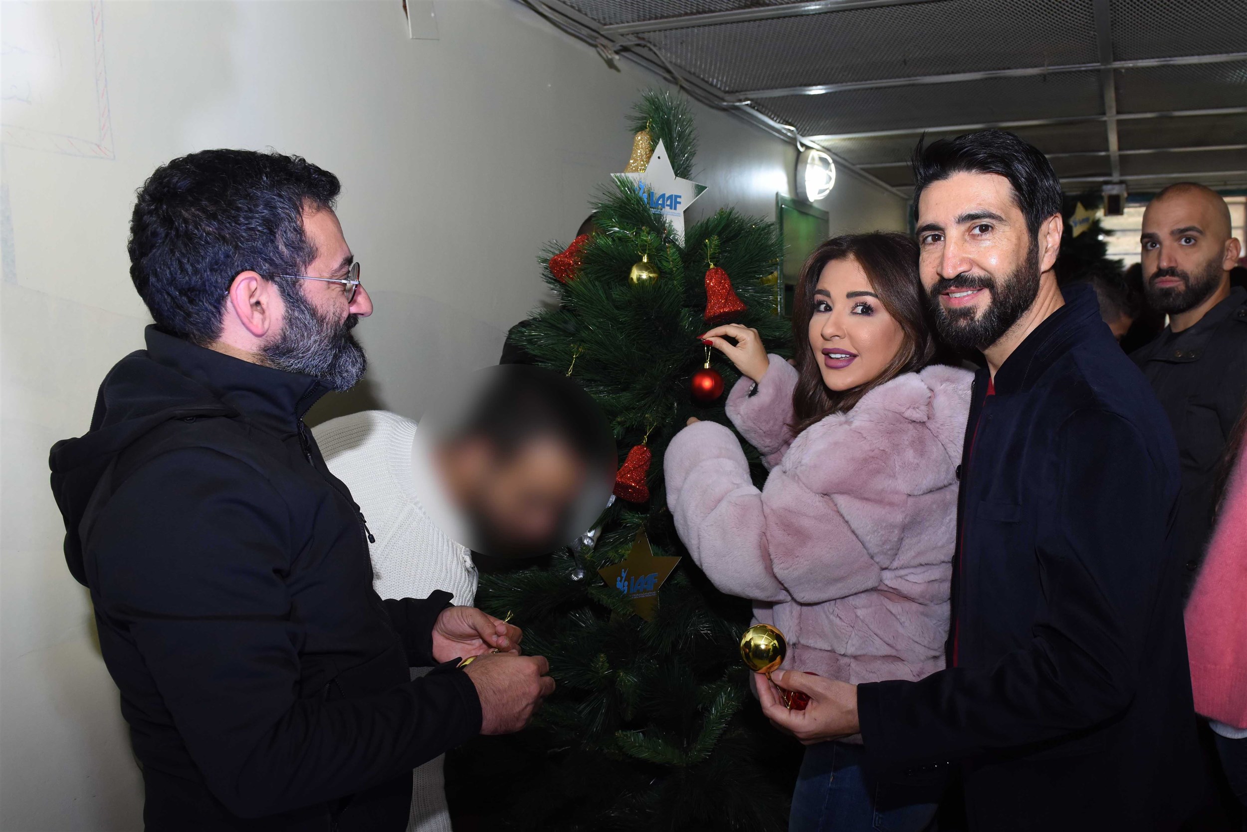 actress magguy bou ghosn, actor wissam sabbagh and actor georges khabbaz gathered around the christmas tree in a holy atmosphere.