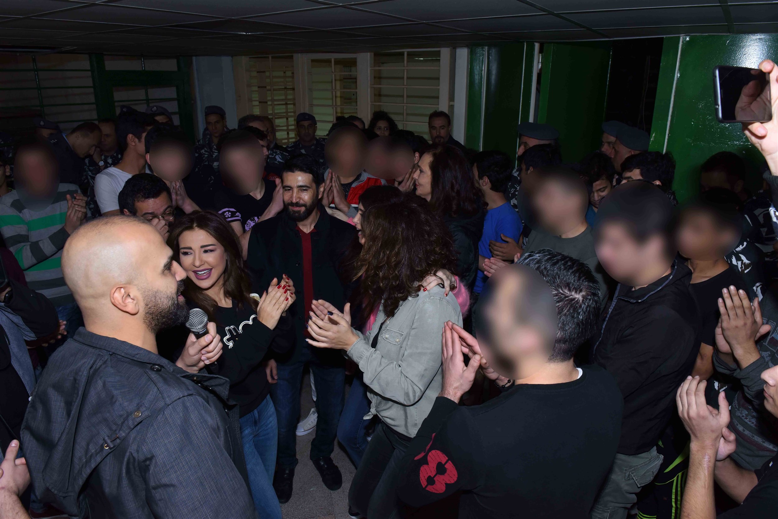 the celebrities, army officials and the juvenile inmates enjoying a celebratory occasion and dancing together while the singer naji osta is singing.